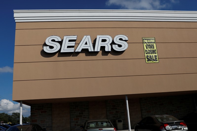 A store closing sale sign is posted next to a Sears logo in New Hyde Park, New York