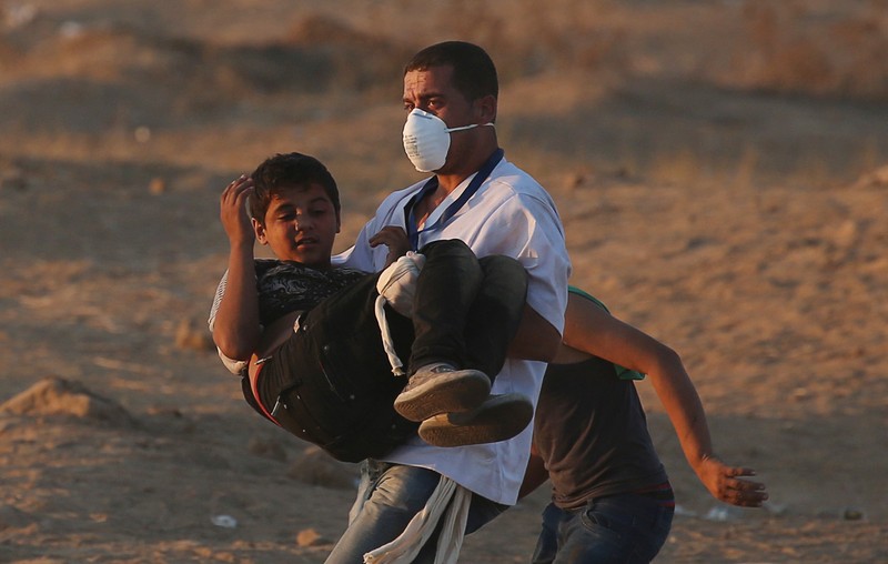 Wounded Palestinian boy is evacuted during a protest at the Israel-Gaza border fence in the southern Gaza Strip