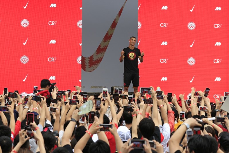FILE PHOTO: Portuguese soccer player Cristiano Ronaldo gestures as fans take photos of him, during an event held by Nike for his annual CR7 Tour in Beijing