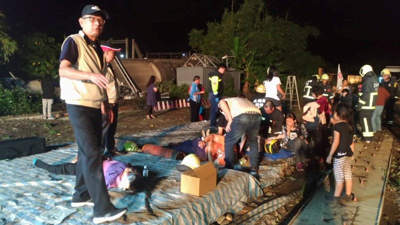 Rescuers tend to injured passengers after a train derailed in Yilan