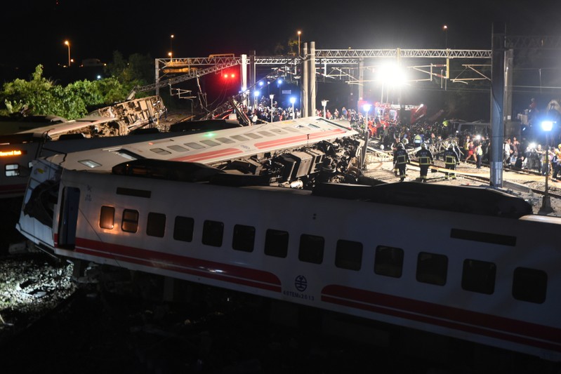 Rescuers search an overturned train in Yilan