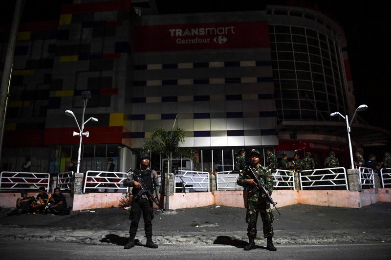 Indonesian police and military personnel secure a shopping center in Palu, Central Sulawesi