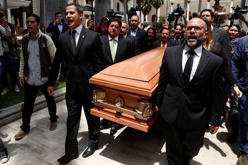 Lawmakers carry the coffin of Fernando Alban during a ceremony at the National Assembly in Caracas