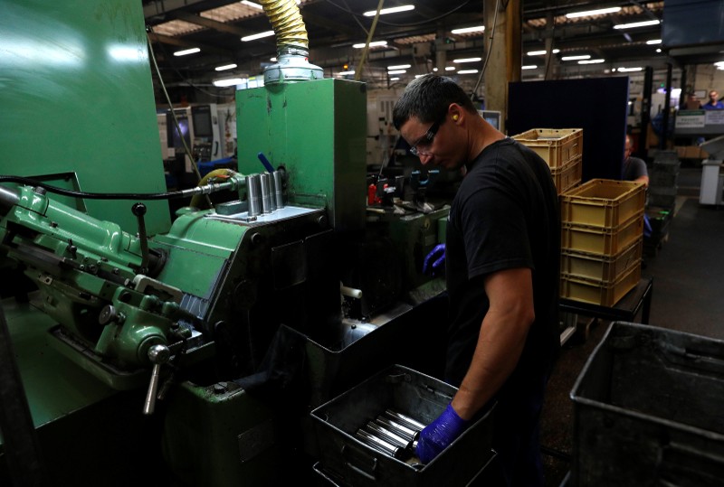 FILE PHOTO: A worker holds a component for a Volvo truck at the Muller manufacturing facility in Redditch
