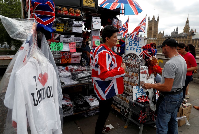 FILE PHOTO: A man tries on a Union Jack-themed jacket at a souvenir stall in London