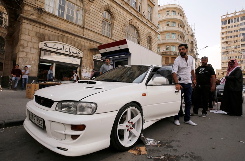 A Jordanian man opens the door of his car in Damascus