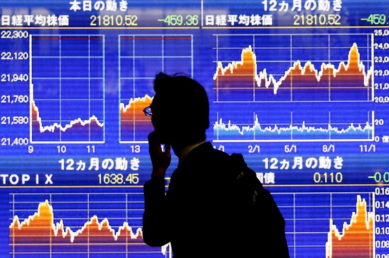A man looks at an electronic stock quotation board showing Japan's Nikkei average outside a brokerage in Tokyo