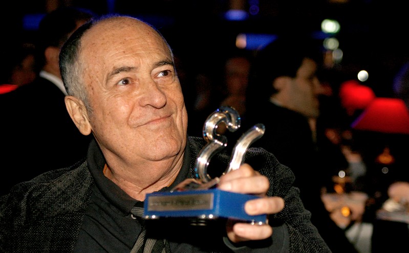 FILE PHOTO: Italian director Bernardo Bertolucci holds his honorary award during the Estoril Film Festival in Estoril