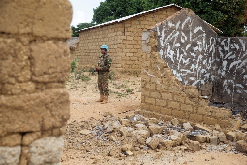 FILE PHOTO: A Bangladeshi United Nations peacekeeping soldier stands among houses destroyed by violence in September, in the abandoned village of Yade, Central African Republic