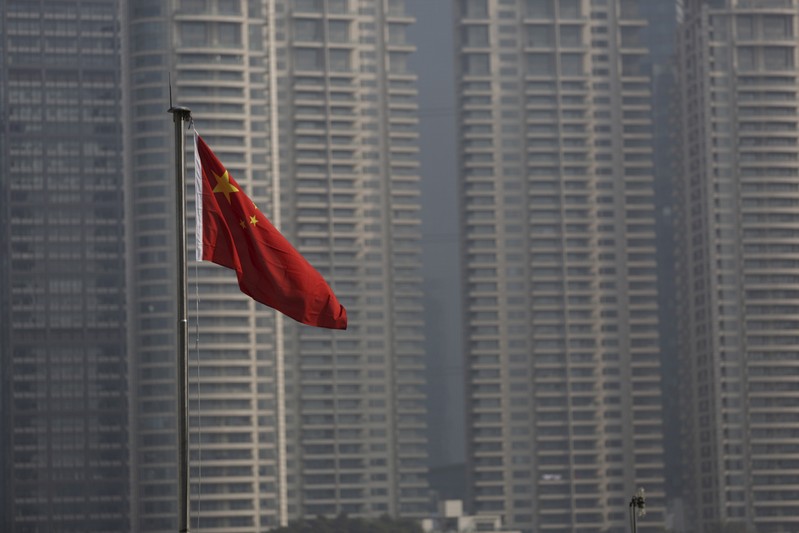 FILE PHOTO: A Chinese flag is seen in front of the financial district of Pudong in Shanghai