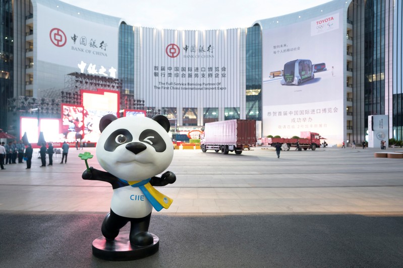 Statue of the China International Import Expo (CIIE)'s mascot is placed in front of a building hanging advertisement of Bank of China, at the venue for the expo in Shanghai