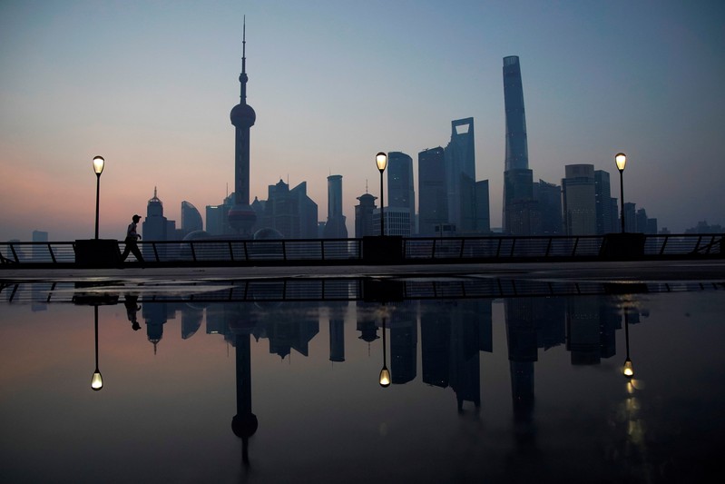 A security guard walks on the bund in front of the financial district of Pudong in Shanghai