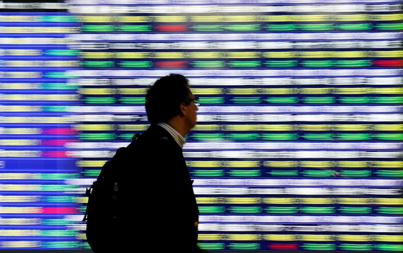 A man walks past an electronic stock quotation board outside a brokerage in Tokyo