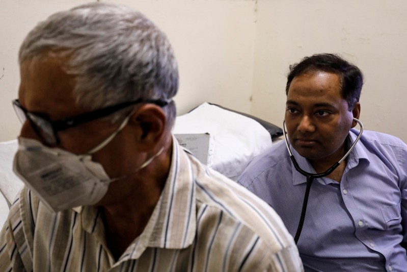 Dr. Desh Deepak, a senior chest physician, treats a patient suffering from breathing difficulties at Ram Manohar Lohia hospital in New Delhi