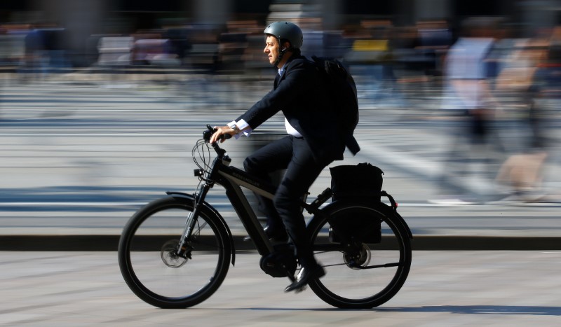 FILE PHOTO - A man rides an electric bicycle, also known as an e-bike, in downtown Milan