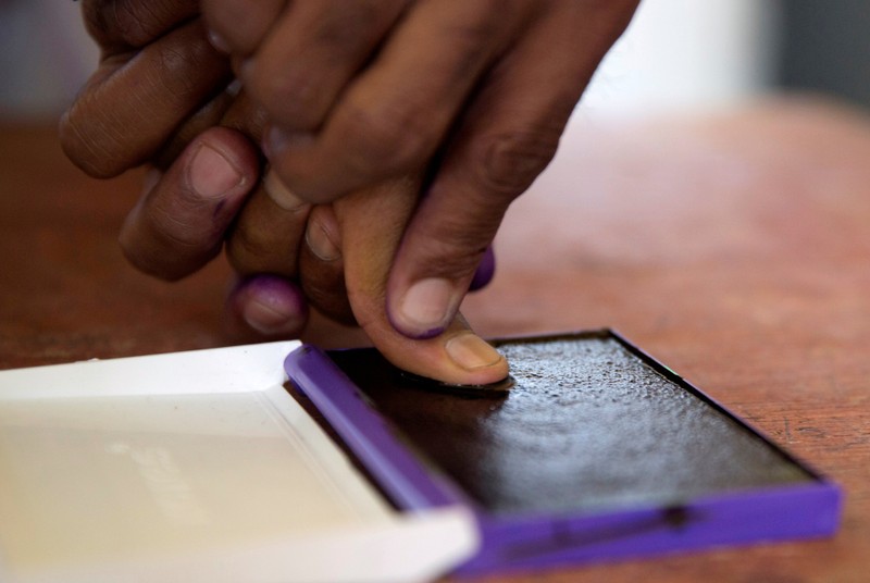 FILE PHOTO: An electoral commission official marks with ink the thumb of a voter after casting his ballot during the presidential election at a polling centre in Analakely, Antananarivo