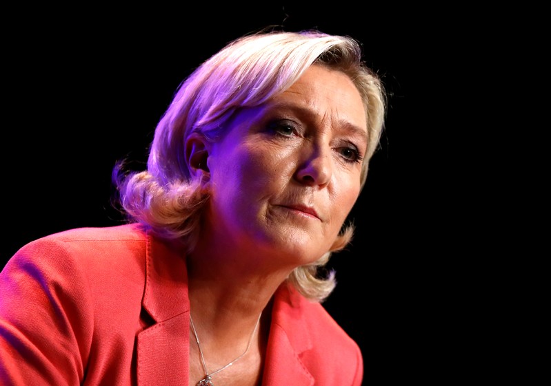 French far-right National Rally (Rassemblement National) party leader Marine Le Pen looks on as she delivers her speech in Mantes-la-Ville
