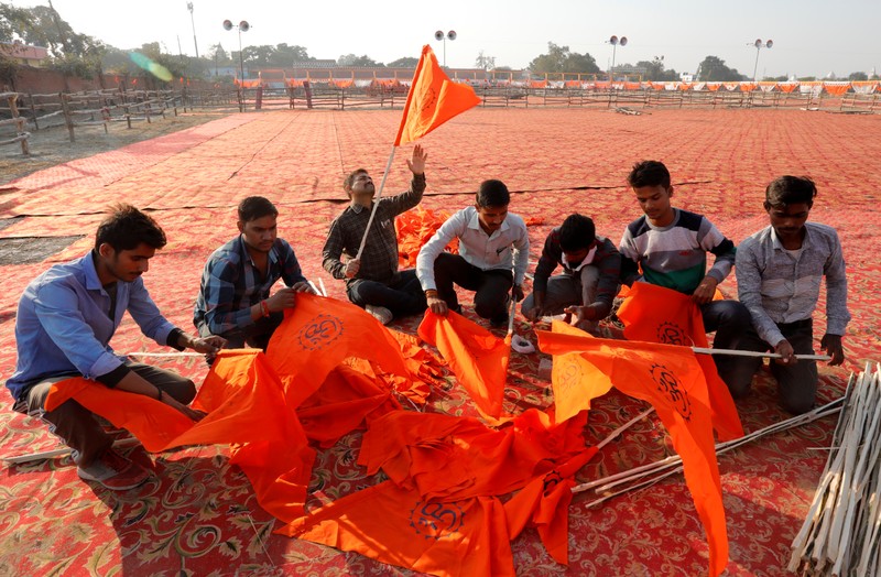 Supporters of the Vishva Hindu Parishad (VHP), a Hindu nationalist organisation, prepare flags at the venue of Sunday's 