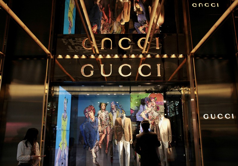 FILE PHOTO: Man watches in front of window display outside a Gucci store in Hong Kong