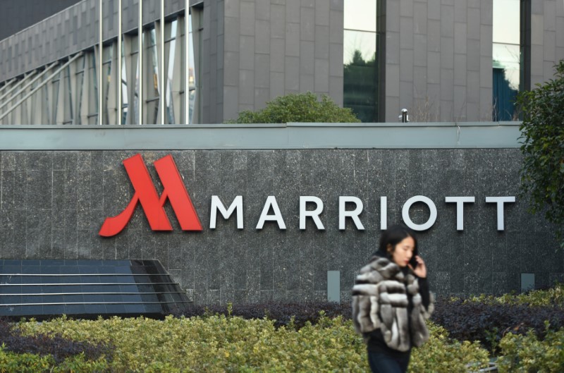 FILE PHOTO - Woman on a mobile phone walks past a Marriott hotel in Hangzhou