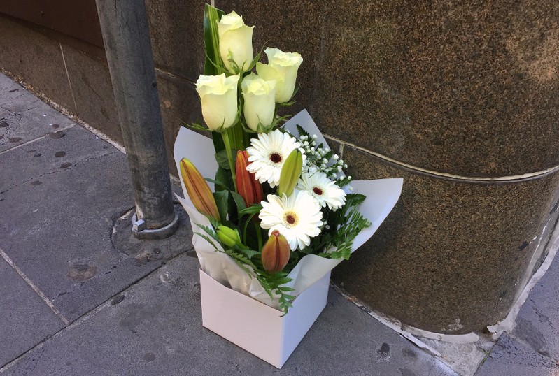 A box of flowers is seen at the site a day after where a man killed one person in what authorities said was a terrorist attack, near the Bourke Street mall in central Melbourne