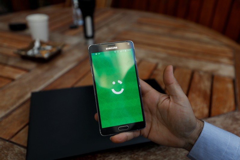 FILE PHOTO: Employee shows the logo of Careem on his mobile in his office in the West Bank city of Ramallah