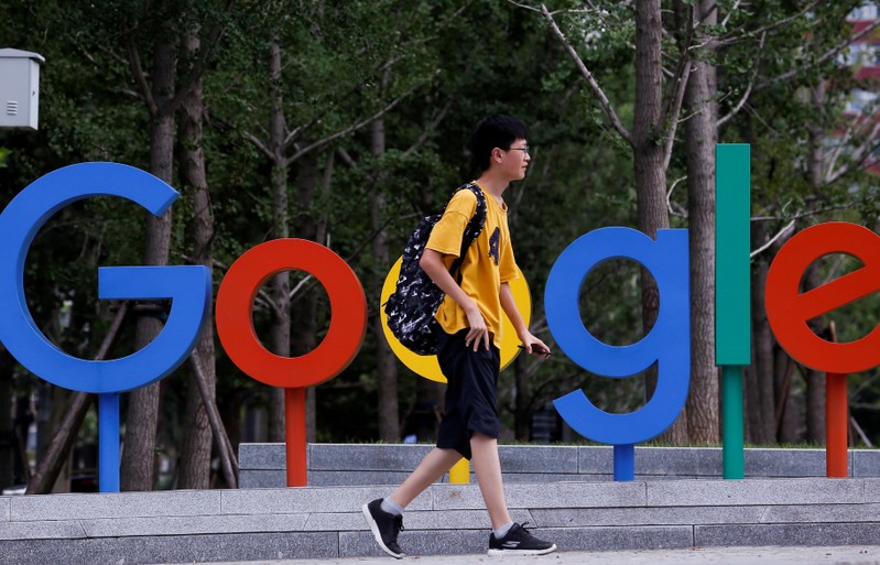 FILE PHOTO: A man walks past the brand logo of Alphabet Inc's Google outside its office in Beijing