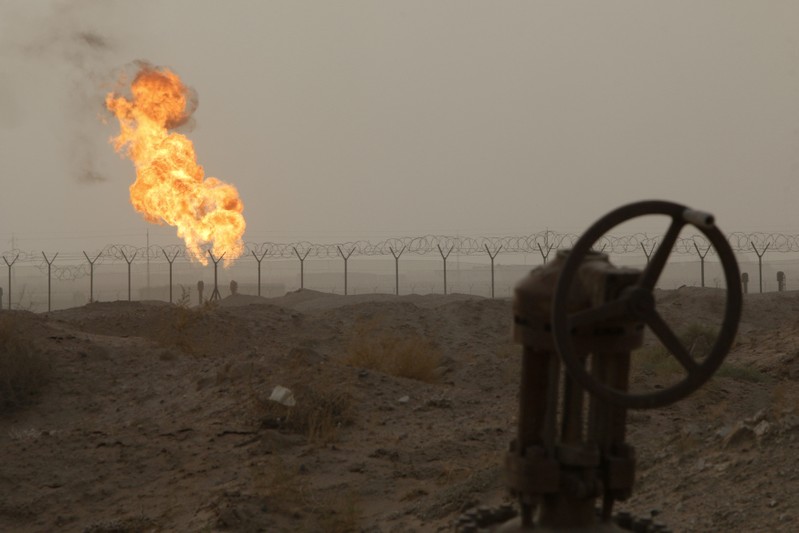 Flames emerge from a pipeline at the oil fields in Basra, southeast of Baghdad
