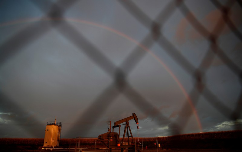 A rainbow is seen over a pumpjack during sunset outside Scheibenhard