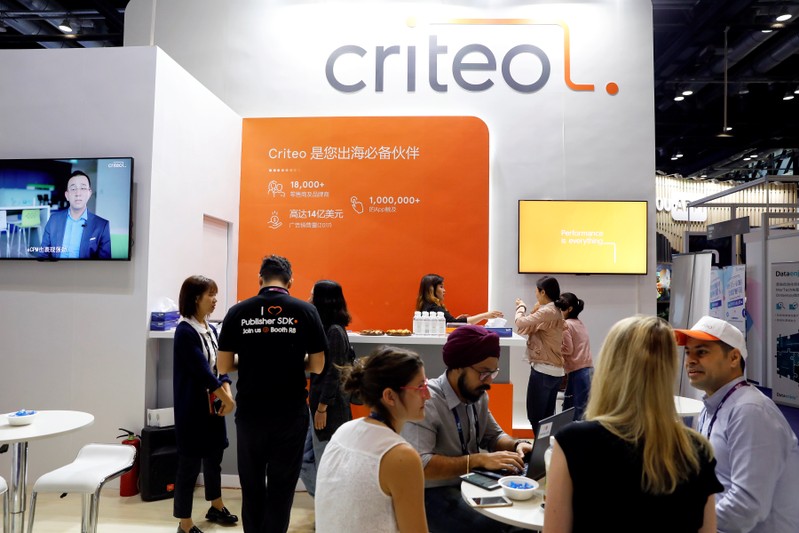 Members of staff work at the Criteo booth during Global Mobile Internet Conference (GMIC) at the National Convention in Beijing