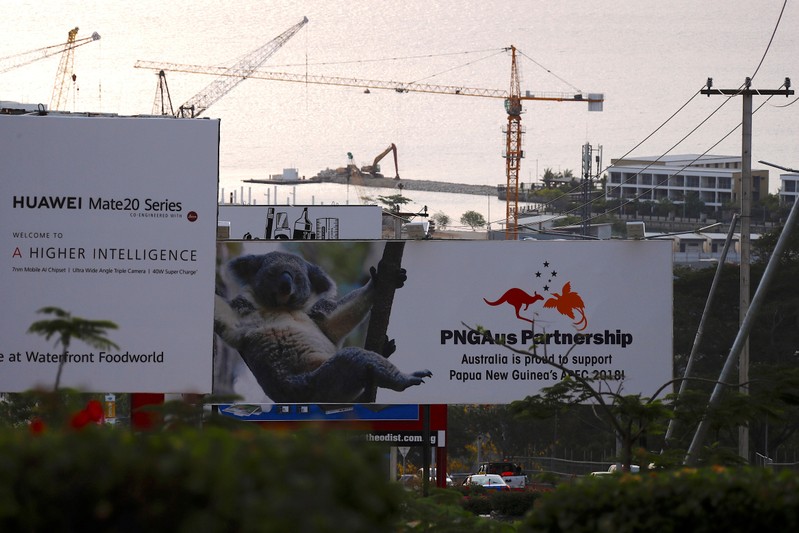 FILE PHOTO: A billboard advertising Chinese's Huawei Technologies Co Ltd can be seen next to another billboard displaying an Australian koala and statement declaring Australia's support for Papua New Guinea, a day after the APEC forum in Port Moresby