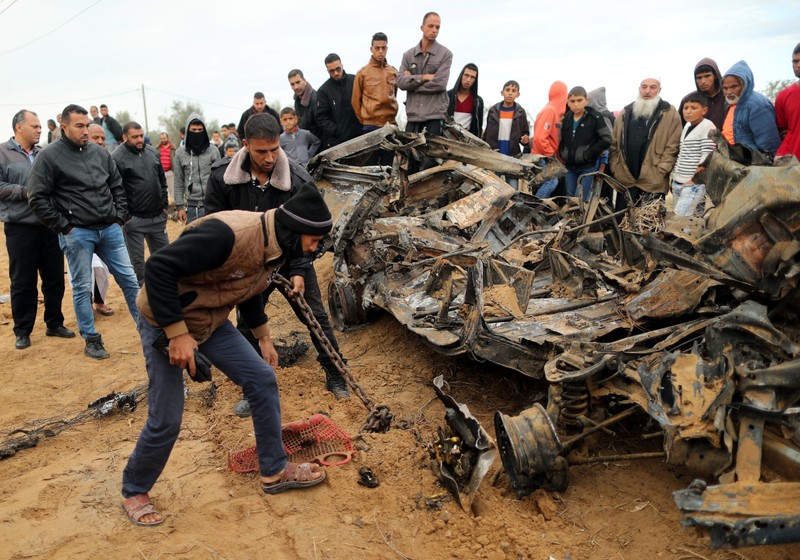 Palestinians inspect the remains of a vehicle that was destroyed in an Israeli air strike, in Khan Younis in the southern Gaza Strip