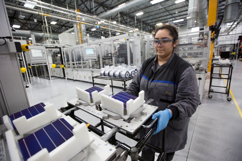 FILE PHOTO: Production operator Diana Correa loads cells into a machine at the SolarWorld solar panel factory in Hillsboro
