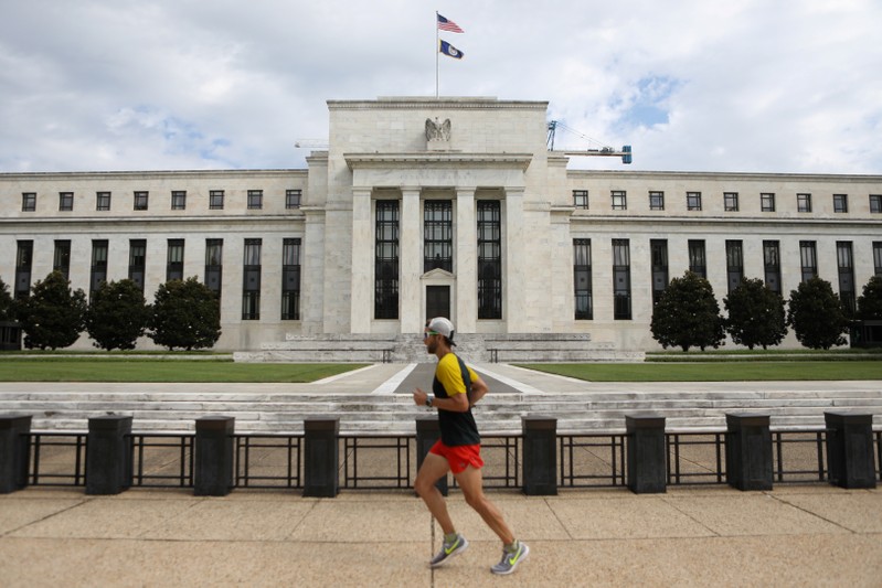 FILE PHOTO: A jogger runs past the Federal Reserve building in Washington, DC