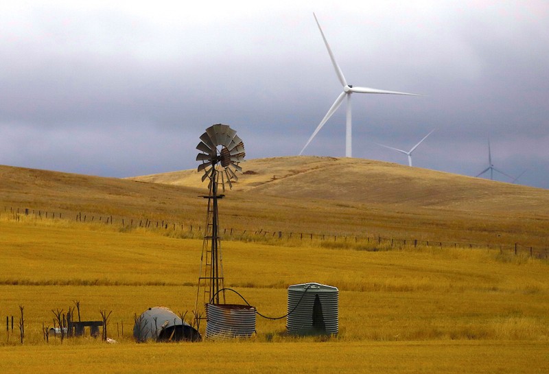 FILE PHOTO: An old windmill stands in front of wind turbines in a paddock on the outskirts of the South Australian town of Jamestown