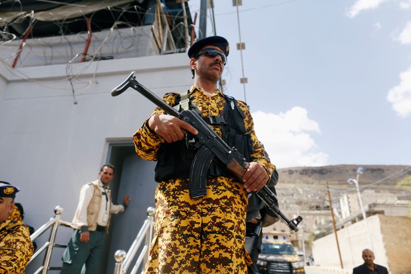 FILE PHOTO: Police trooper stands guard as wounded Houthi fighters demonstrate outside the United Nations offices to demand for medical treatment abroad, in Sanaa, Yemen