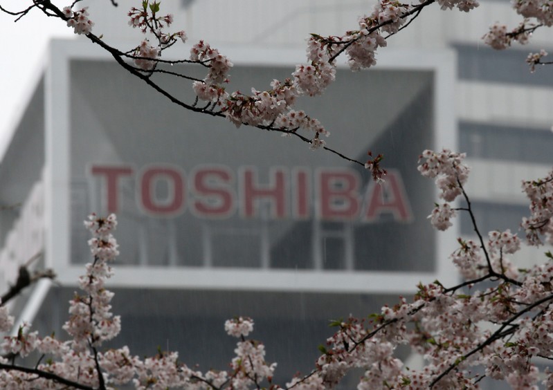 FILE PHOTO: The logo of Toshiba Corp is seen behind cherry blossoms at the company's headquarters in Tokyo