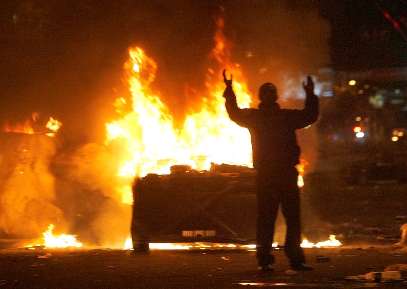 FILE PHOTO: Protester reacts near burning police cars in central Yerevan