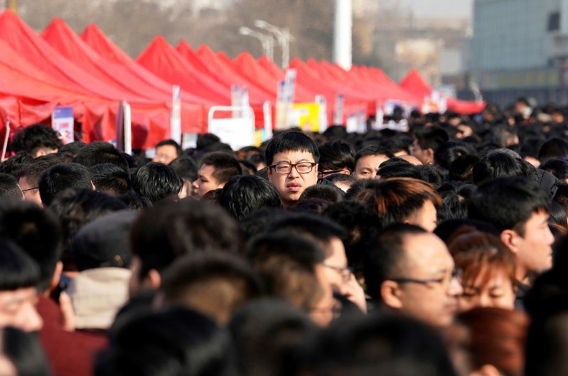 FILE PHOTO: Job seekers crowd a job fair at Liberation Square in Shijiazhuang