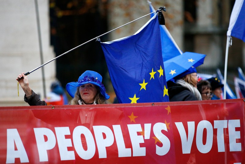 Anti-Brexit demonstrators wave flags during a protest opposite the Houses of Parliament, London