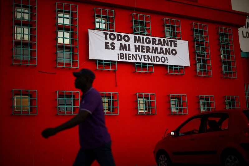 FILE PHOTO: An Haitian immigrant walks past a banner that reads 