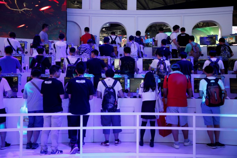 FILE PHOTO - People play computer games at the China Digital Entertainment Expo and Conference (ChinaJoy) in Shanghai