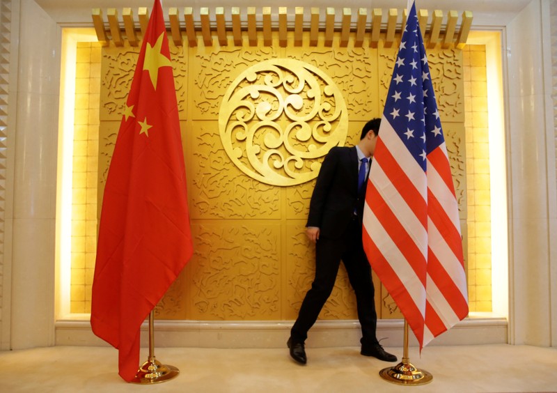 A staff member sets up Chinese and U.S. flags for a meeting in Beijing, China.