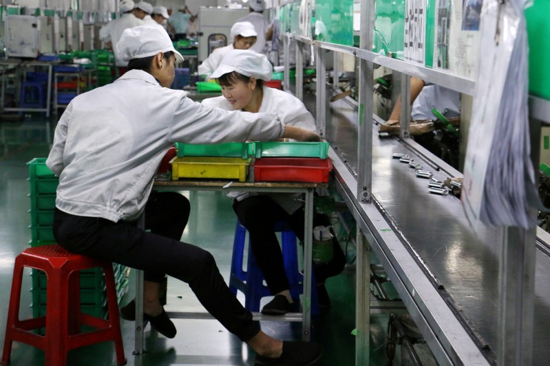 FILE PHOTO: Employees work at a production line of lithium ion batteries inside a factory in Dongguan