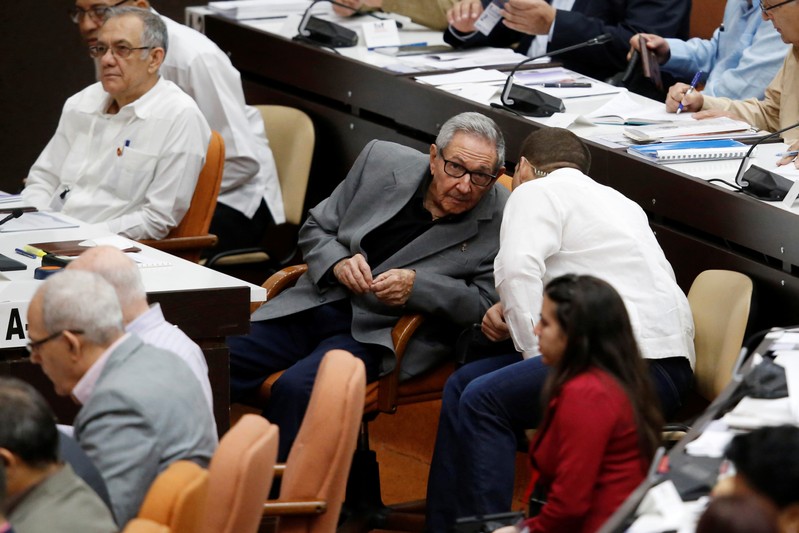 Cuba's former President Raul Castro (C-L) talks to his grandson and bodyguard Raul Rodriguez Castro during a session of the National Assembly in Havana