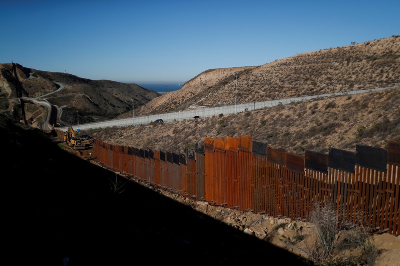 Workers on the U.S. side, work on the border wall between Mexico and the U.S., as seen from Tijuana