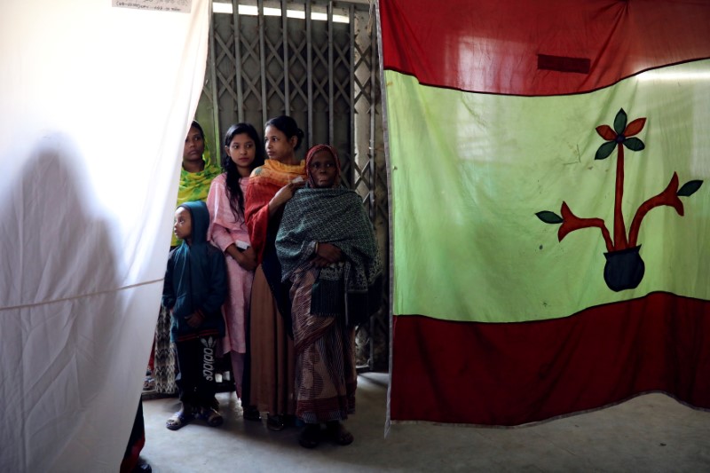 Voters wait to cast their vote at a voting center during the general election in Dhaka
