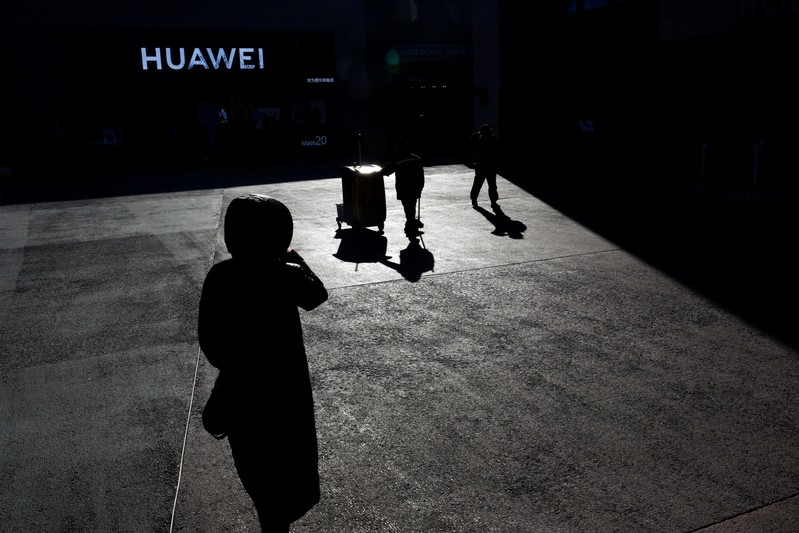 FILE PHOTO: People walk past a Huawei shop in Beijing
