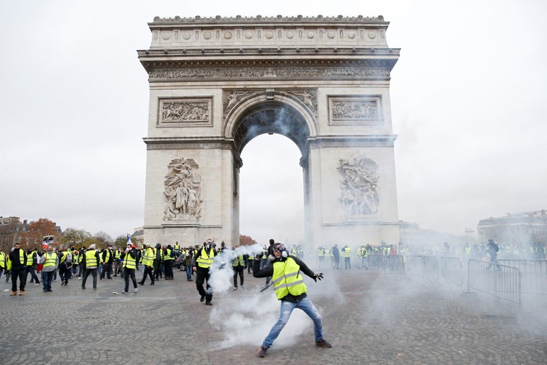 Tear gas floats in the air near the Arc de Triomphe as protesters wearing yellow vests, a symbol of a French drivers' protest against higher diesel taxes, demonstrate in Paris