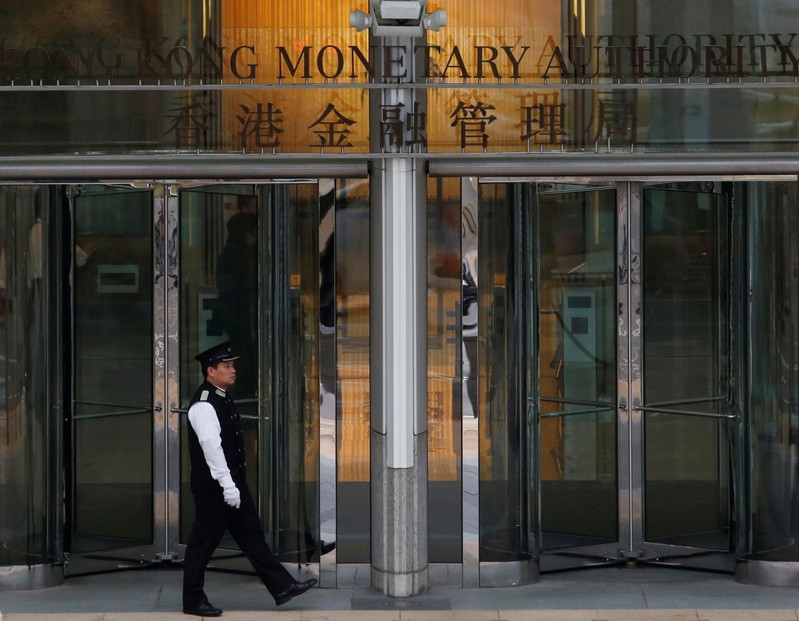 FILE PHOTO: An attendant walks outside the entrance to Hong Kong Monetary Authority in Hong Kong